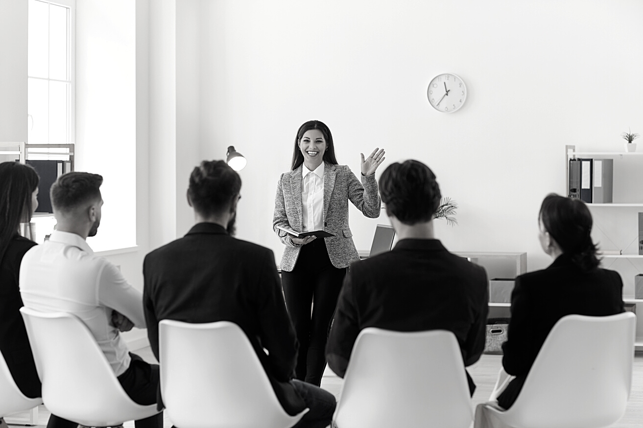 Smiling Company Manager or Team Leader Greeting Workers or Interns in Corporate Meeting